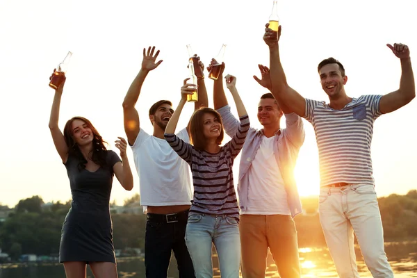 Jeunes avec de la bière au bord de la rivière — Photo