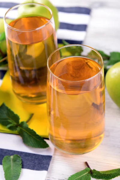 Bicchieri di succo di mela con frutta e menta fresca sul tavolo da vicino — Foto Stock