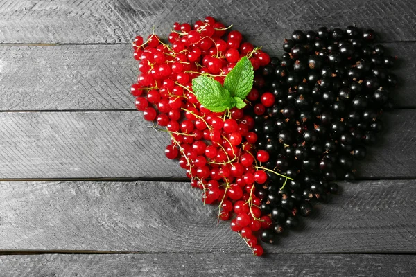 Серце з лісовими ягодами на дерев'яному фоні — стокове фото