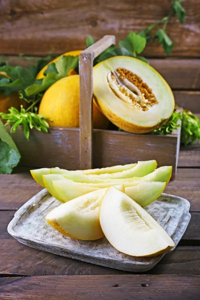 Rijpe meloenen met groene bladeren — Stockfoto