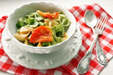 Kavrulmuş kuşkonmaz ve ahşap masa arka plan üzerinde kase sebze ile lezzetli makarna