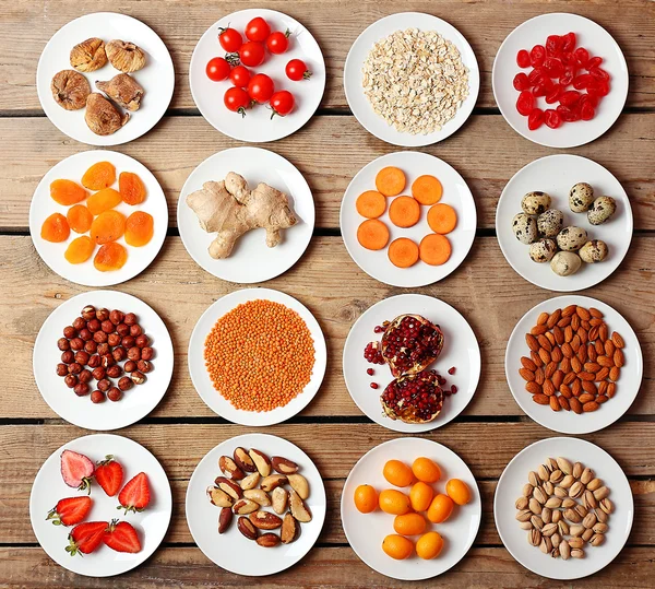 Different products on saucers on wooden table, top view — Stock Photo, Image