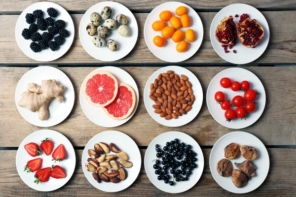 Different products on saucers on wooden table, top view — Stock Photo, Image