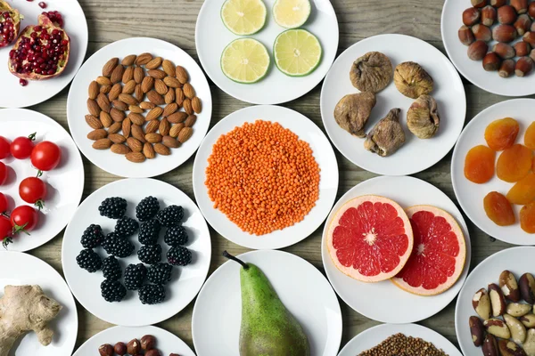 Different products on saucers on wooden table, top view — Stock Photo, Image