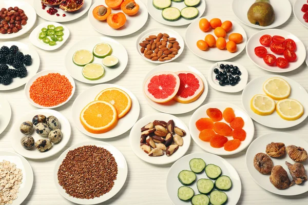 Different products on saucers on wooden table, top view — Stock Photo, Image