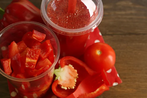 Ensalada de verduras y frutas rojas y bebida fresca saludable en tazas de plástico sobre fondo de madera. Colorido concepto de dieta —  Fotos de Stock