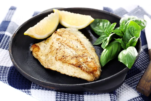 Schotel van visfilet met basilicum en citroen op tafel close-up — Stockfoto