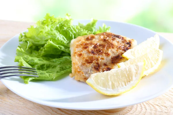 Maträtt av fiskfilé med sallad och citron på bordet på nära håll — Stockfoto