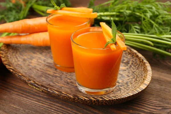 Óculos de suco de cenoura com legumes na mesa de perto — Fotografia de Stock