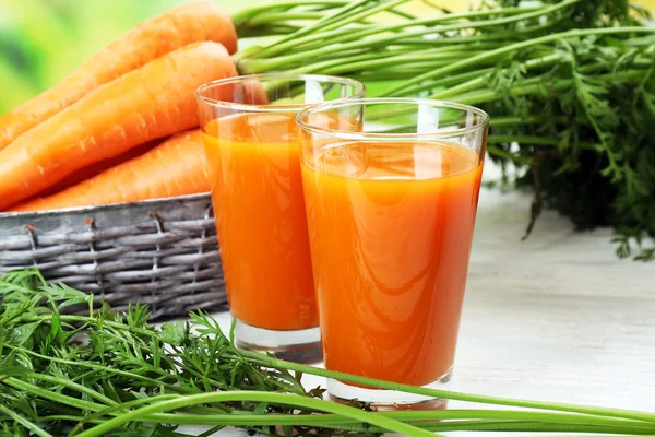 Glasögon med morotsjuice med grönsaker på bordet på nära håll — Stockfoto