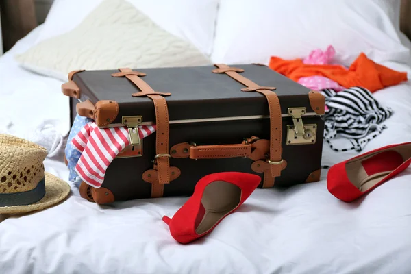 Kufr s oblečením na posteli — Stock fotografie
