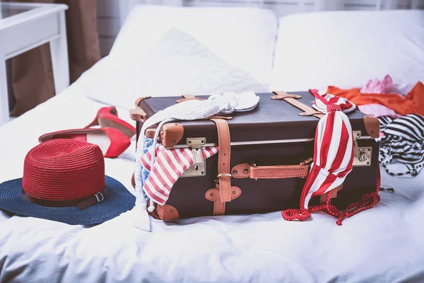 Suitcase with clothing on bed — Stock Photo, Image