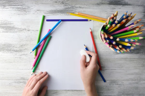 Hand with color pencils and blank paper — Stock Photo, Image