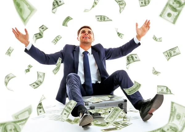 Uomo d'affari seduto sotto la pioggia di soldi — Foto Stock