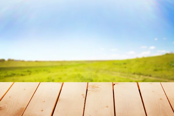 Dřevěný stůl s pozadím pole — Stock fotografie