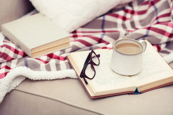 Taza de café con libro en sofá en la sala de estar — Foto de Stock