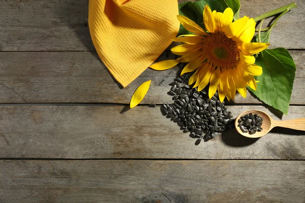Girassol brilhante bonito com sementes na mesa de madeira perto — Fotografia de Stock