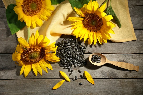 Mooie lichte zonnebloemen met zaden op houten tafel close-up — Stockfoto