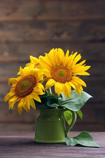 美丽明亮的向日葵，在木制的背景上的水罐里 — 图库照片