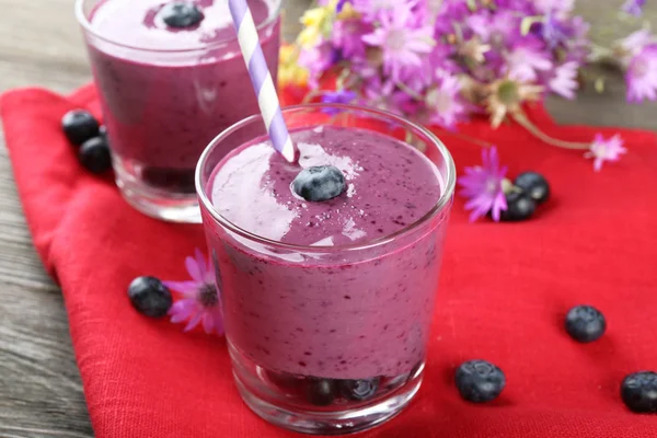 Glasögon av blueberry smoothie på röd Servett, närbild — Stockfoto