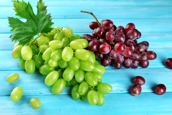 Fehér és vörös szőlő, kék fa háttér — Stock Fotó