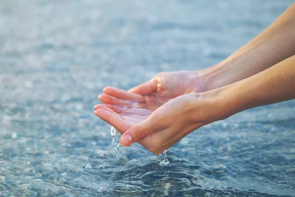 Mani femminili toccano l'acqua di mare — Foto Stock