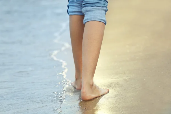 Vrouw die over zandstrand loopt — Stockfoto