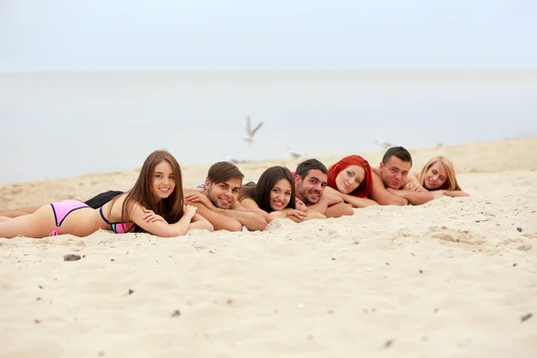 Young people lying on beach — Stock Photo, Image