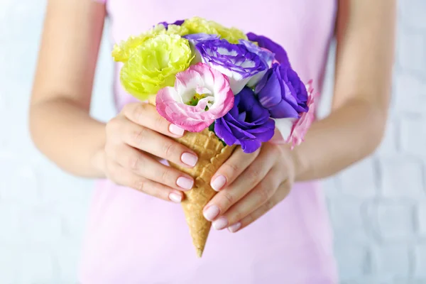 Женщина держит дикие цветы в вафельном макете — стоковое фото