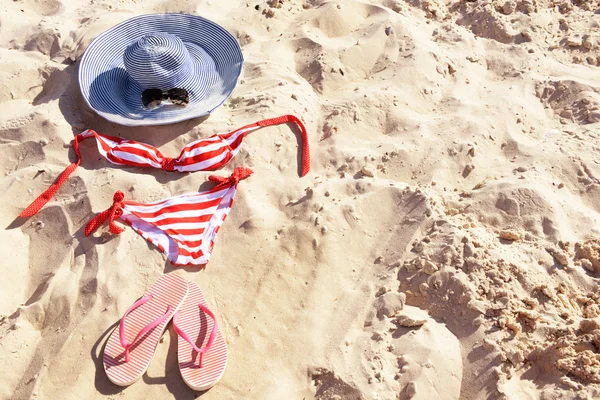 Flip flops, μαγιό και καπέλο για closeup άμμο στην παραλία — Φωτογραφία Αρχείου
