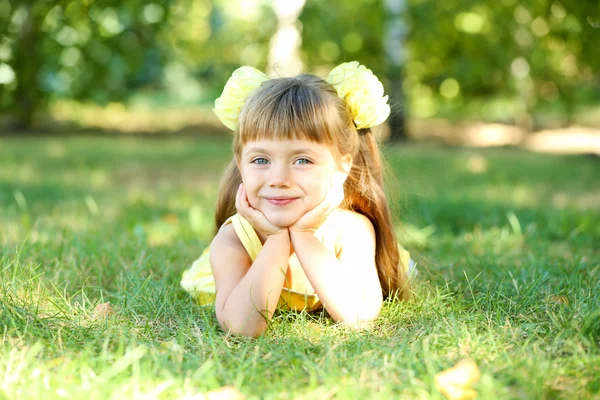 Küçük kız portre dışarıda çimenlerin üzerinde — Stok fotoğraf