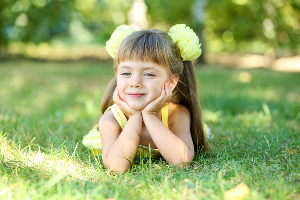 Küçük kız portre dışarıda çimenlerin üzerinde — Stok fotoğraf