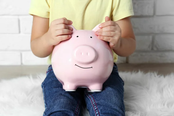 Niña con la caja de dinero de cerdo — Foto de Stock