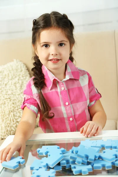 小さな女の子が家にパズルで遊んで — ストック写真