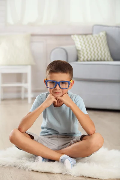 Little boy sitting on carpet — Stock Photo, Image