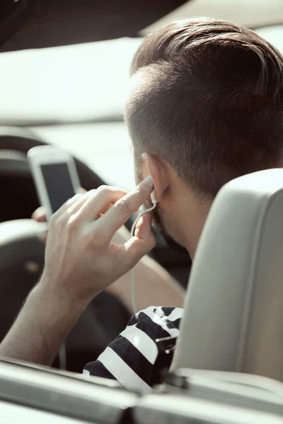 Homme avec casque dans la voiture — Photo