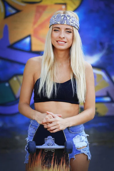 Mujer joven con tabla de patinar —  Fotos de Stock