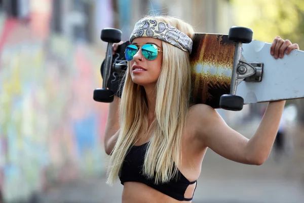 Mujer joven con tabla de patinar — Foto de Stock