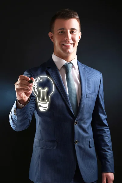 Businessman drawing idea light bulb, close up