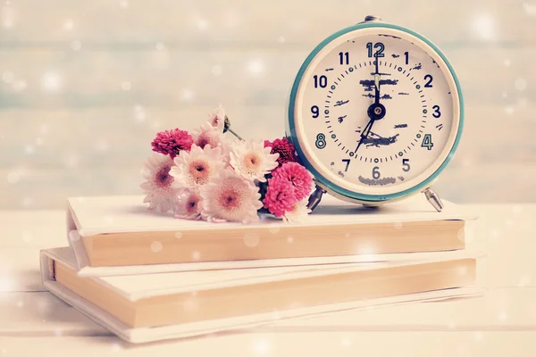 Çalar saat ve kitaplar ile çiçekler — Stok fotoğraf
