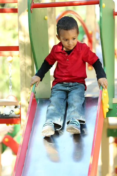 Niño jugando en el parque infantil — Foto de Stock