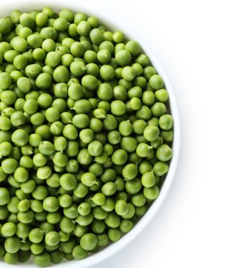 Taze taze bezelyeler beyaz kasede izole edilmiş.