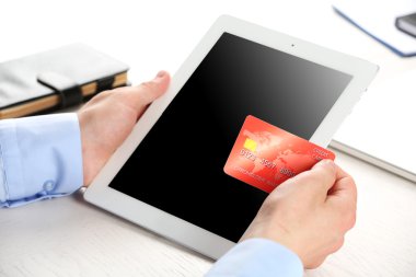 Kredi kartı ve tablet işyeri arka planda tutan adam