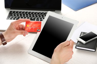 Kredi kartı ve tablet işyeri arka planda tutan adam