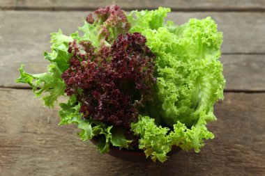 Ahşap masa üzerinde kase taze karışık yeşil salata yakın çekim