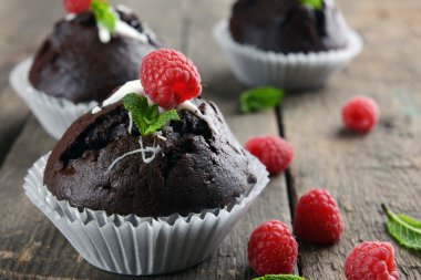Çilek ve ahşap masa üzerinde taze nane ile lezzetli çikolata cupcakes yakın çekim