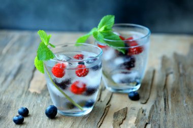 Bardak soğuk ferahlatıcı yaz içeceği çilek ve masada buz küpleri ile yakın çekim