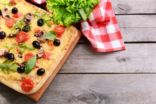 Leckere hausgemachte Pizza auf dem Tisch aus nächster Nähe — Stockfoto