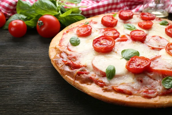 Heerlijke pizza met kaas en cherry tomaten op houten tafel, close-up — Stockfoto