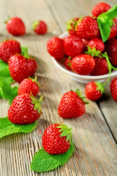 Rijpe aardbeien in schotel op houten tafel, close-up — Stockfoto